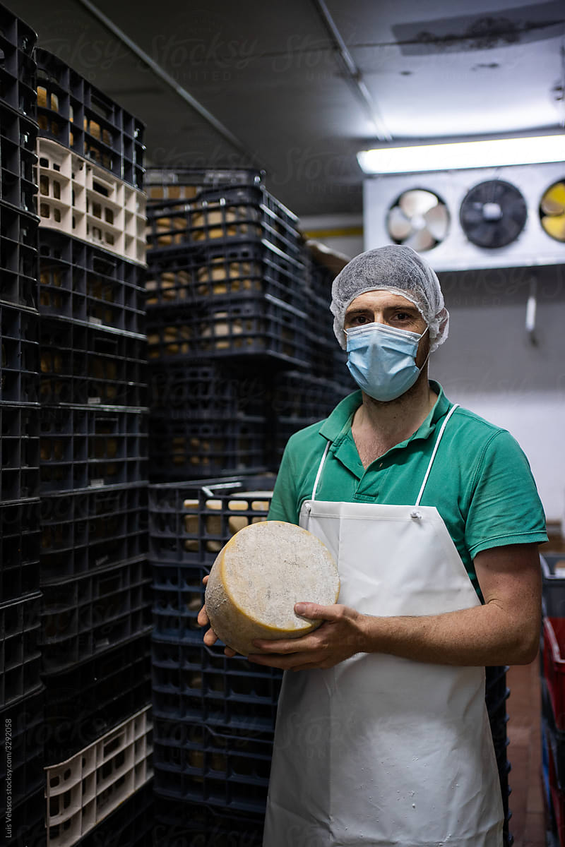 Portrait Of A Employee With Mask In A Cheese Factory.