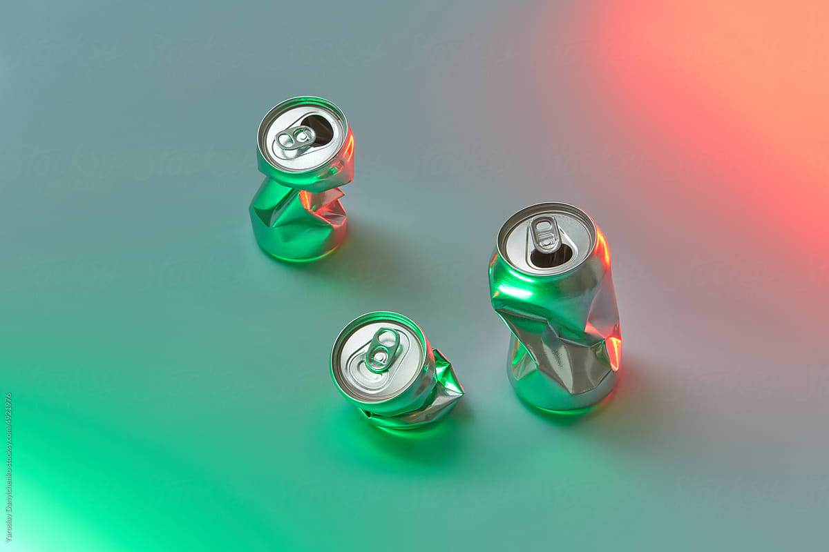 Crushed aluminum cans on neon background.