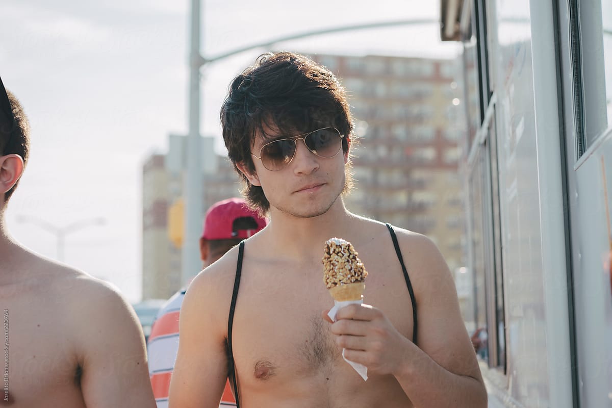 Young Men Friends Lining Up to Buy Soft Serve Ice Cream from Food Truck in Hot Sunny Summer in Rockaway Beach