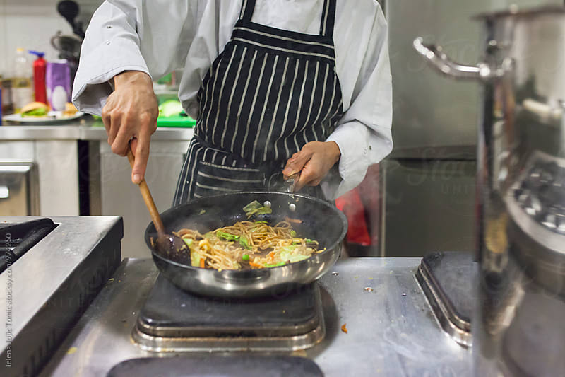 Professional cook prepares a meal in a restaurant kitchen
