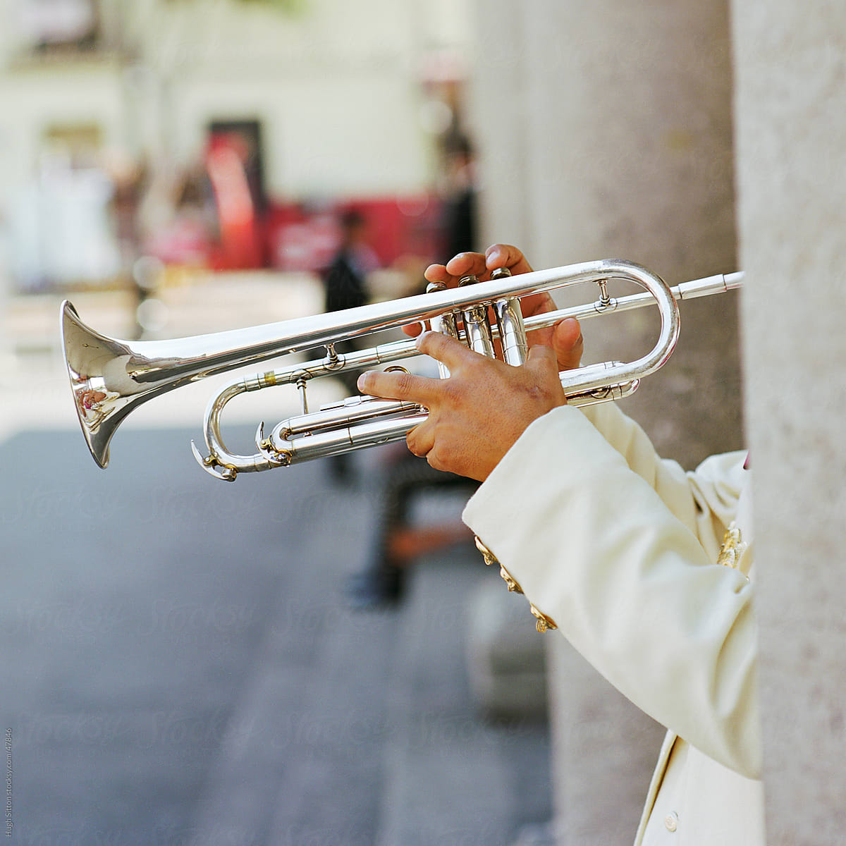 Musician playing trumpet, partially obscured by pillar. Mexico