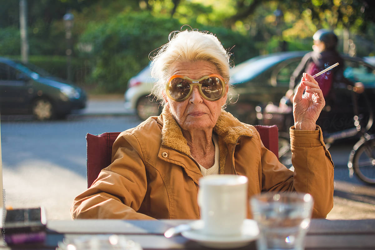 Senior woman smoking and having coffee
