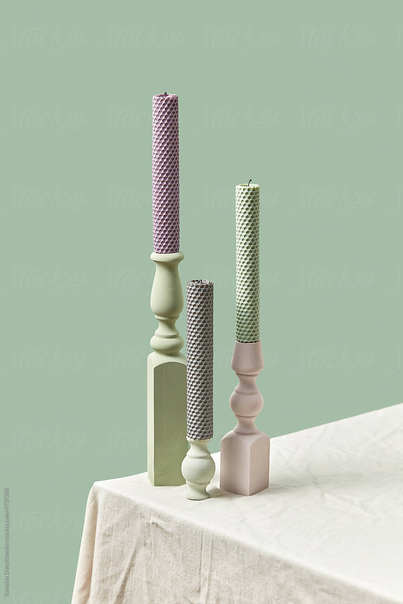 Candles in pastel colors in fancy holders.