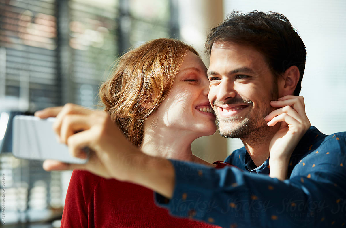 Happy Woman Kissing Man While Talking Selfie Del Colaborador De Stocksy Alto Images Stocksy