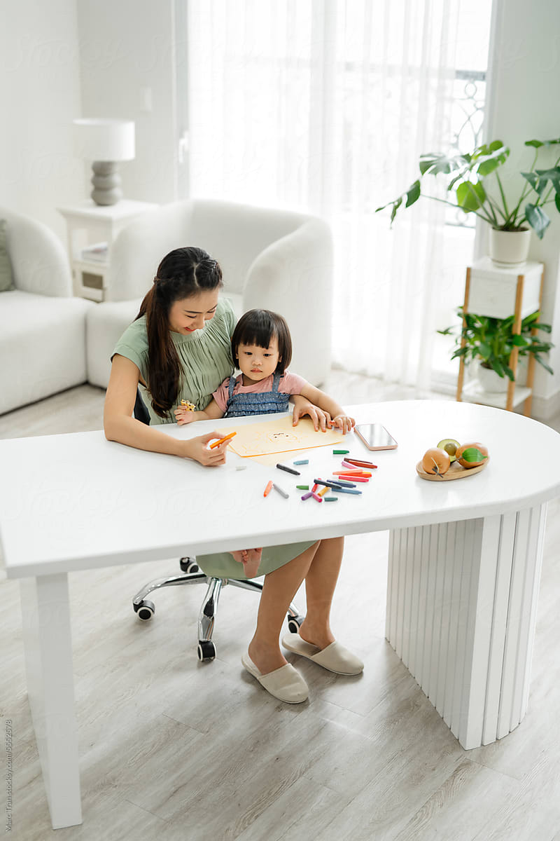 Portrait of asian woman and her daughter drawing together