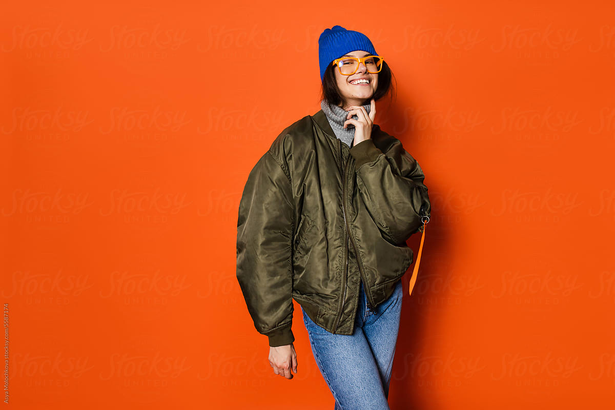 Cheerful young woman on an orange studio background