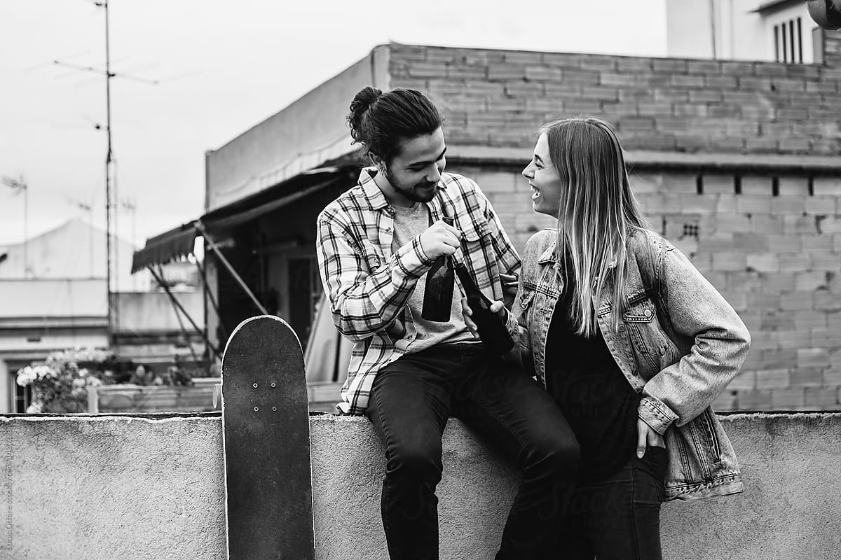 Young man and young woman drinking beer on the rooftop