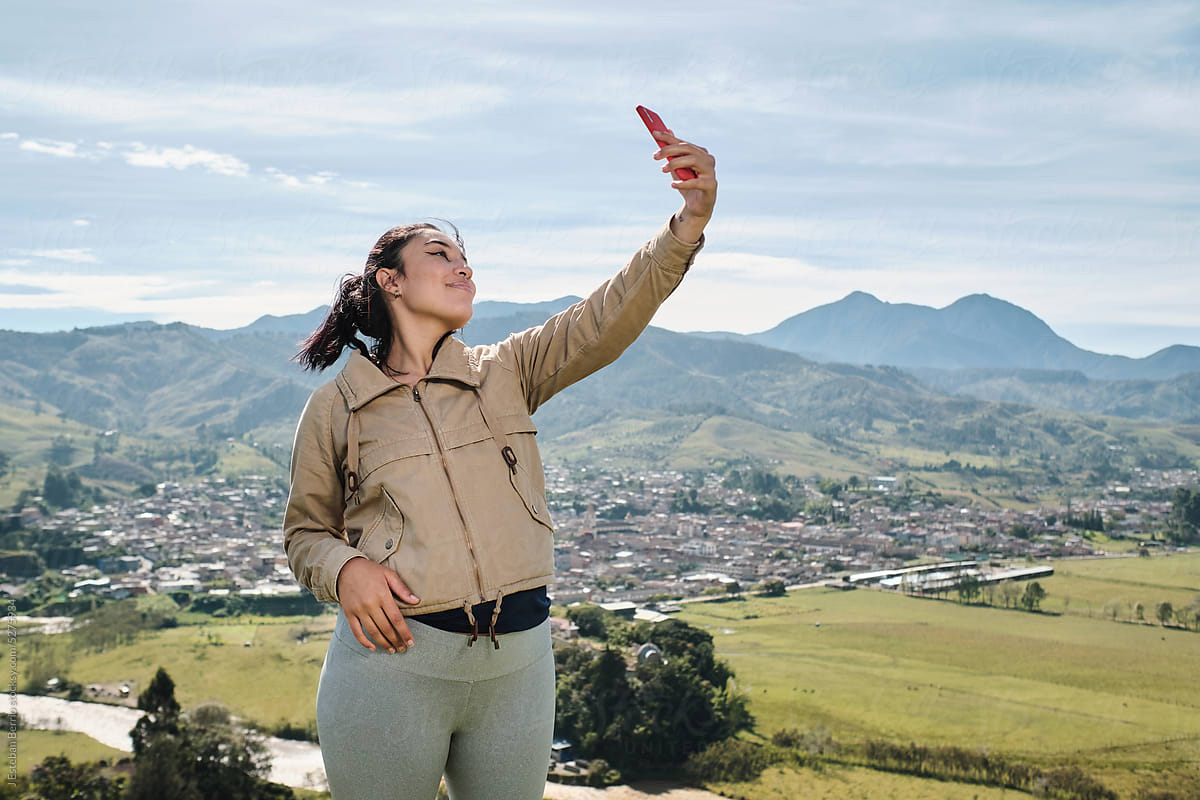 Pregnant woman taking a selfie on a mountain