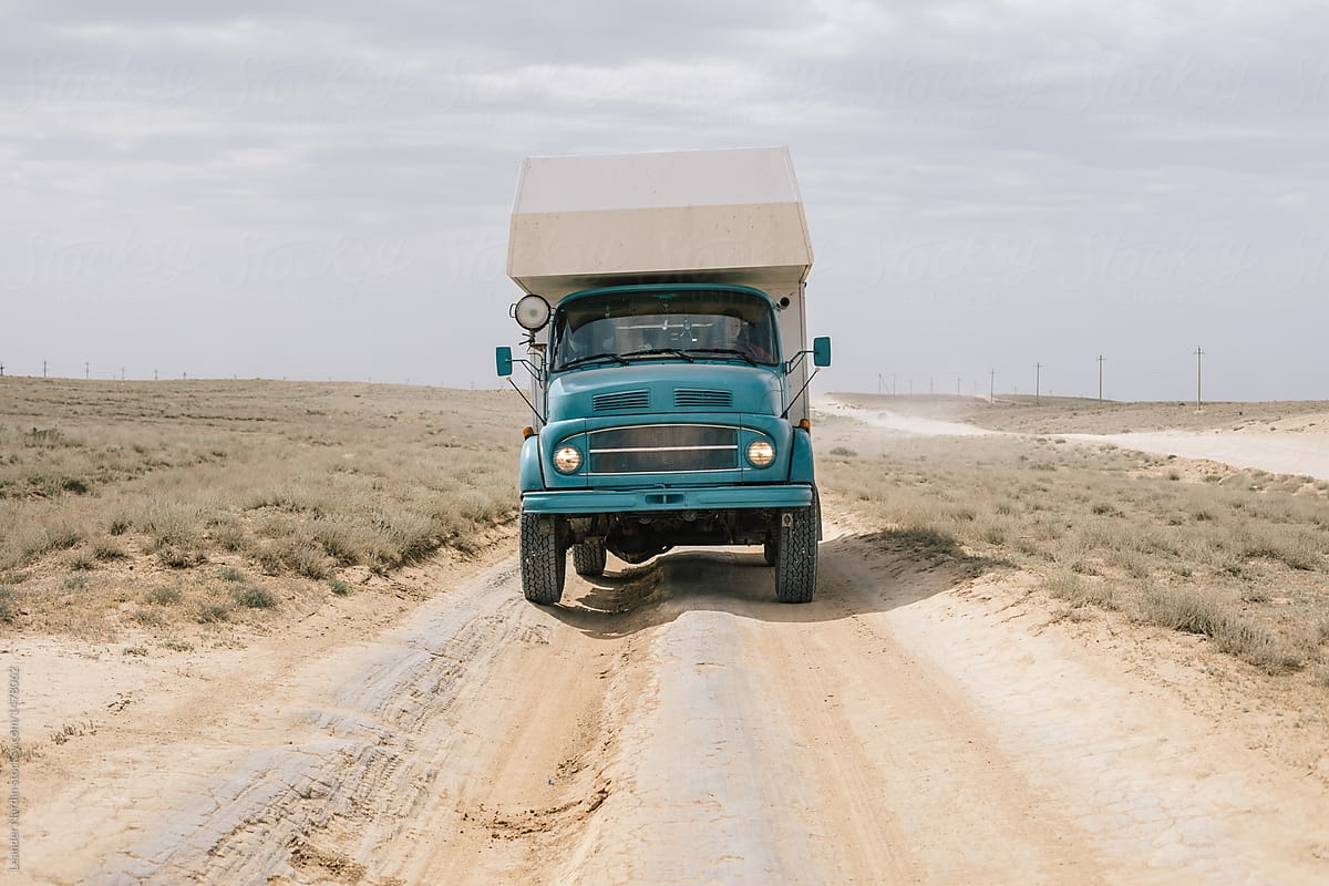 blue camping truck on rugged desert road