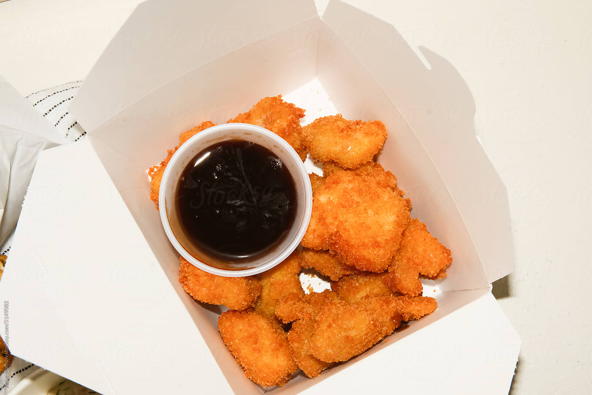 Container of chicken nuggets and sauce.