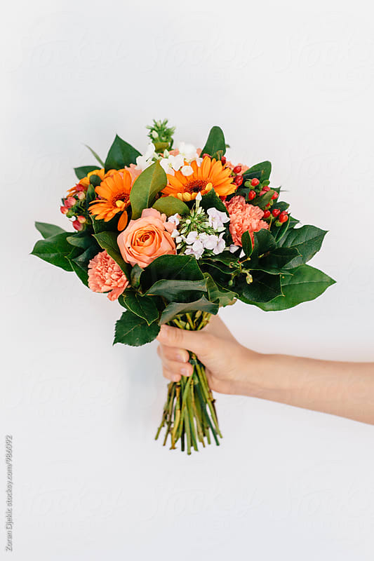 Woman's hand holding a bouquet of flowers.