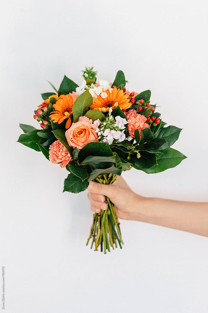 Woman\'s hand holding a bouquet of flowers.