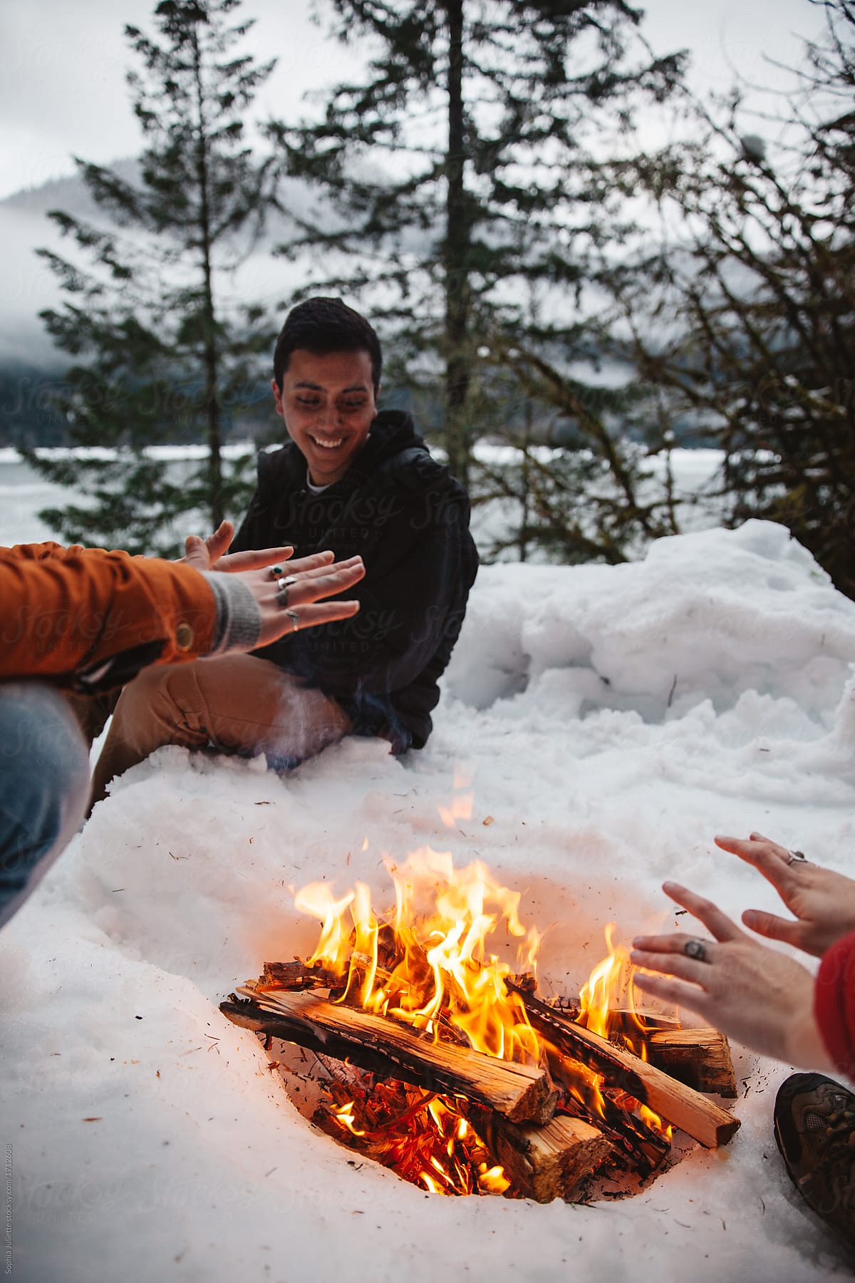Friends Sitting Around a Warm Fire in the Snow