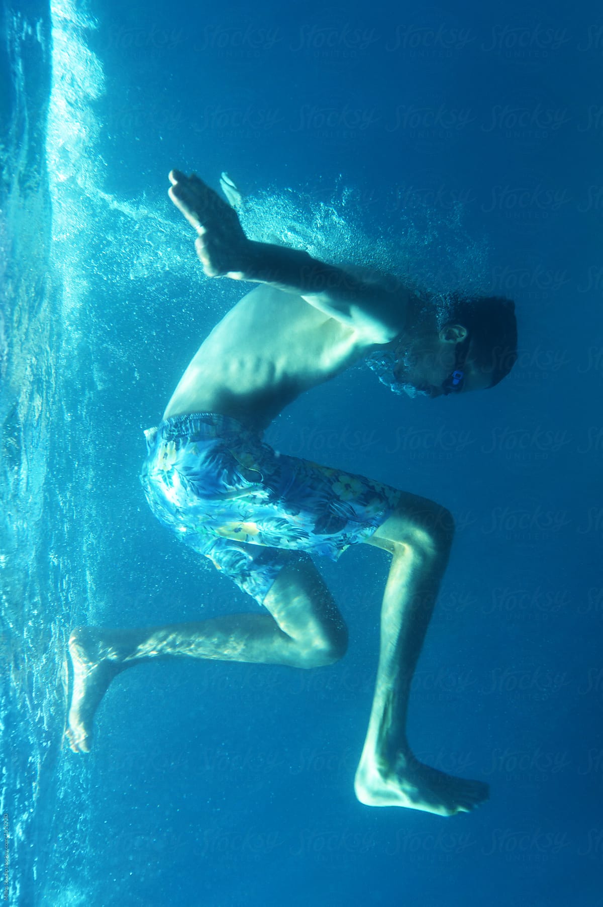 Snorkeler jumping in blue water