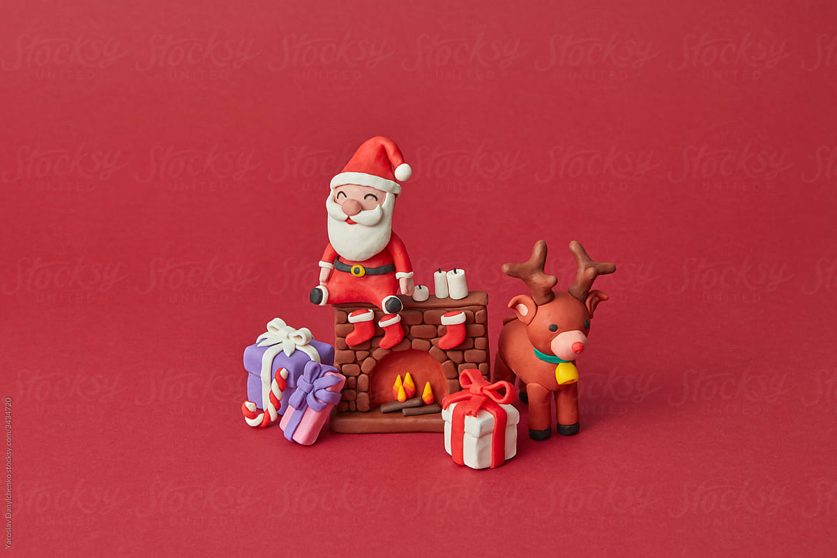 Plasticine Santa Claus on fireplace with gifts and deer.