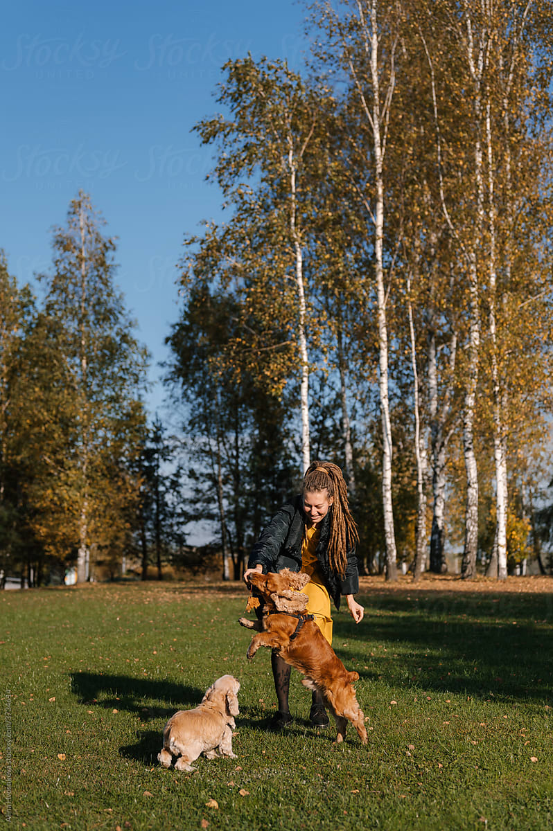 Female owner playing with dog in autumn