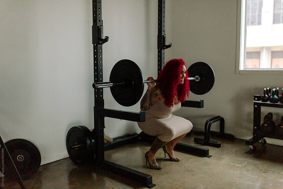 Woman in dress and heels doing squat lift