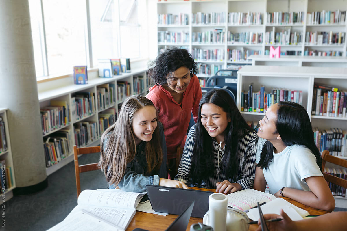 Group of highschool students studying together in library