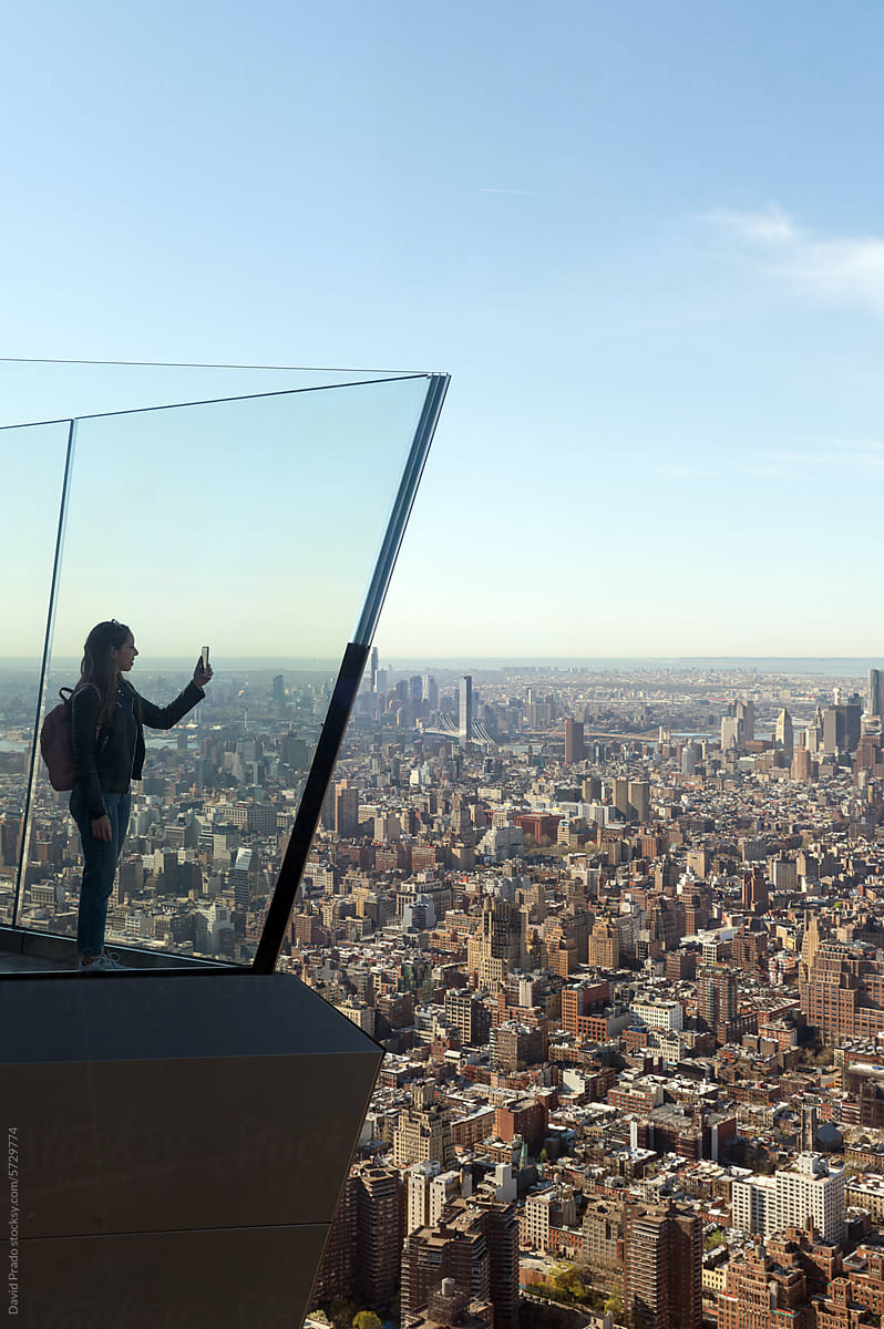 Woman overlooking expansive Manhattan skyline from The Edge