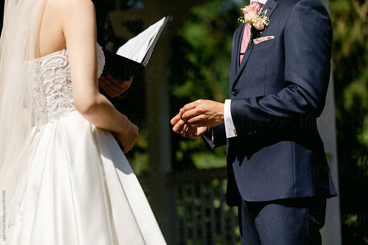 A Groom Holds His Wife's Ring during the Wedding Ceremony