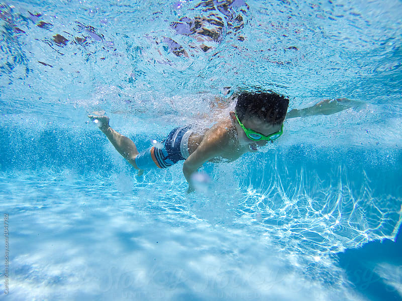 Boy swimming fast under water