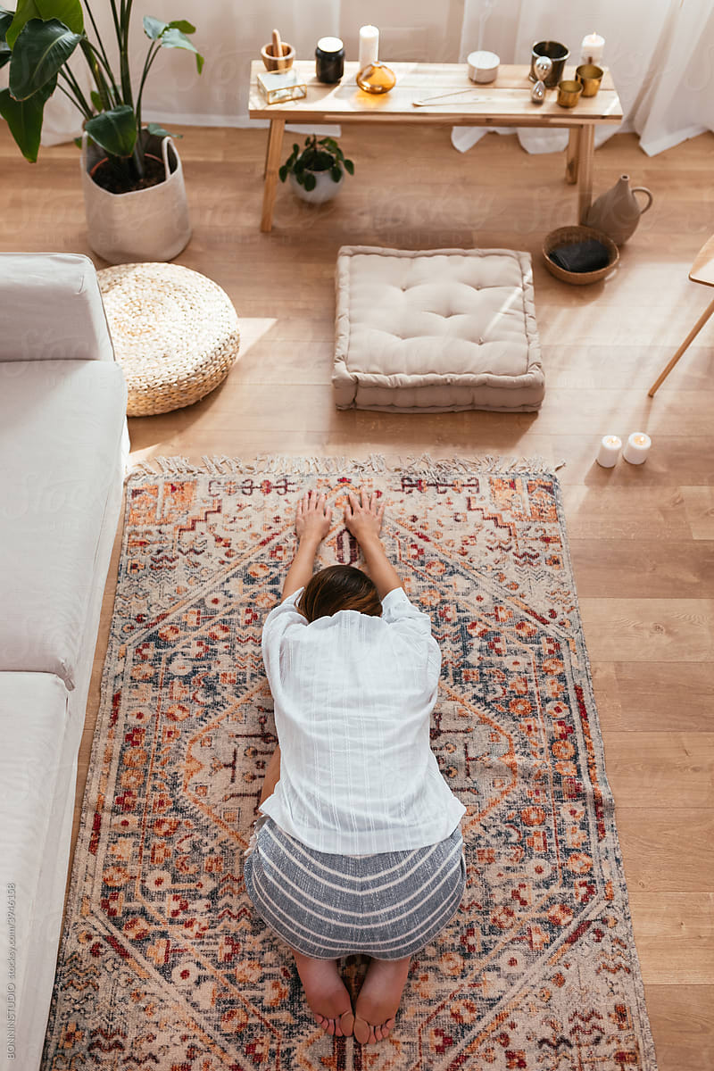 Unrecognizable woman stretching on carpet