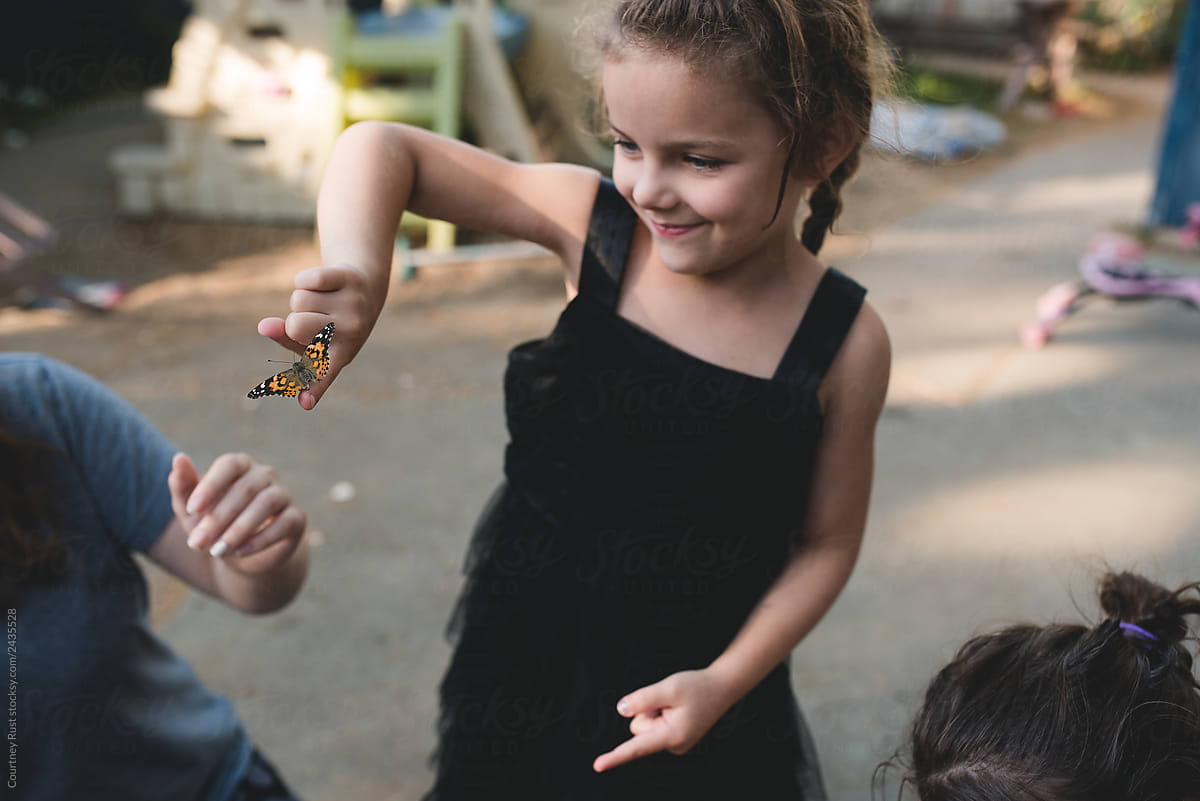 Excited little girl handling a butterfly