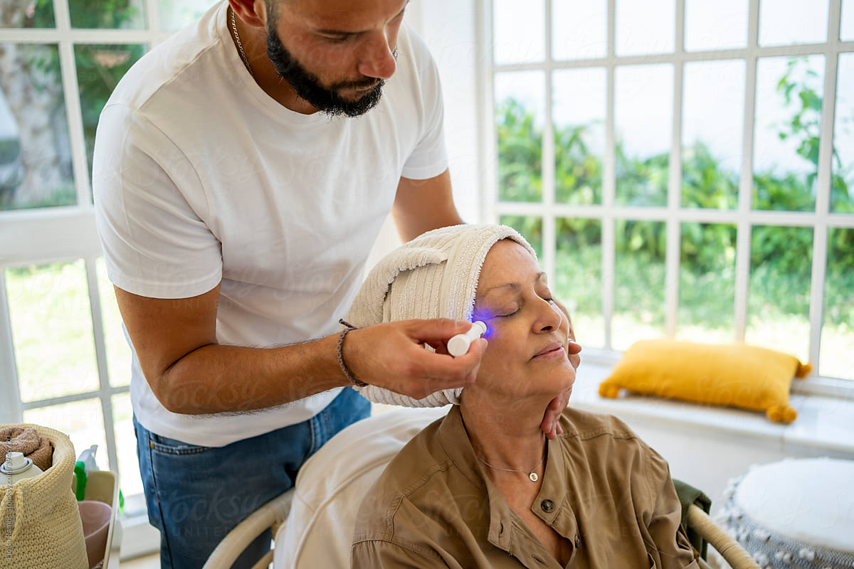 Senior woman getting a facial massage at home