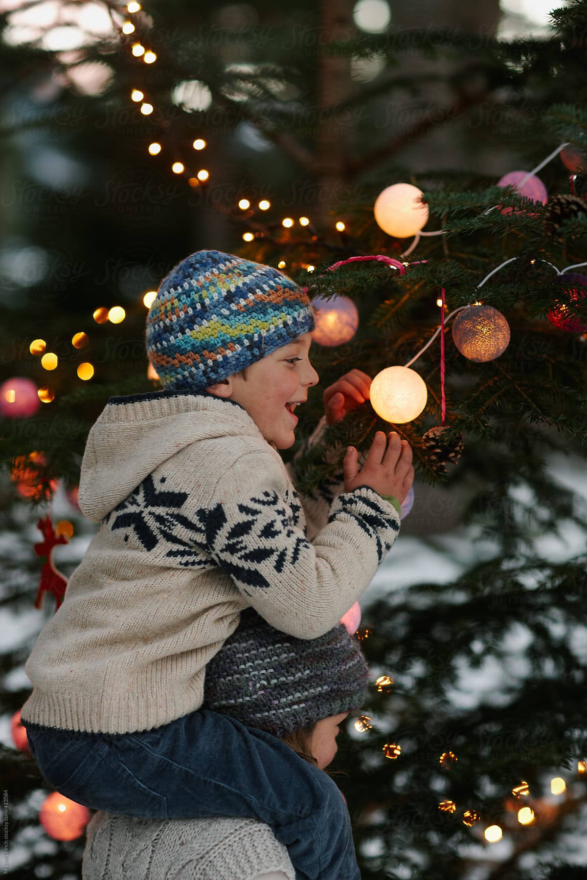 Children enjoying a moment around the christmas tree