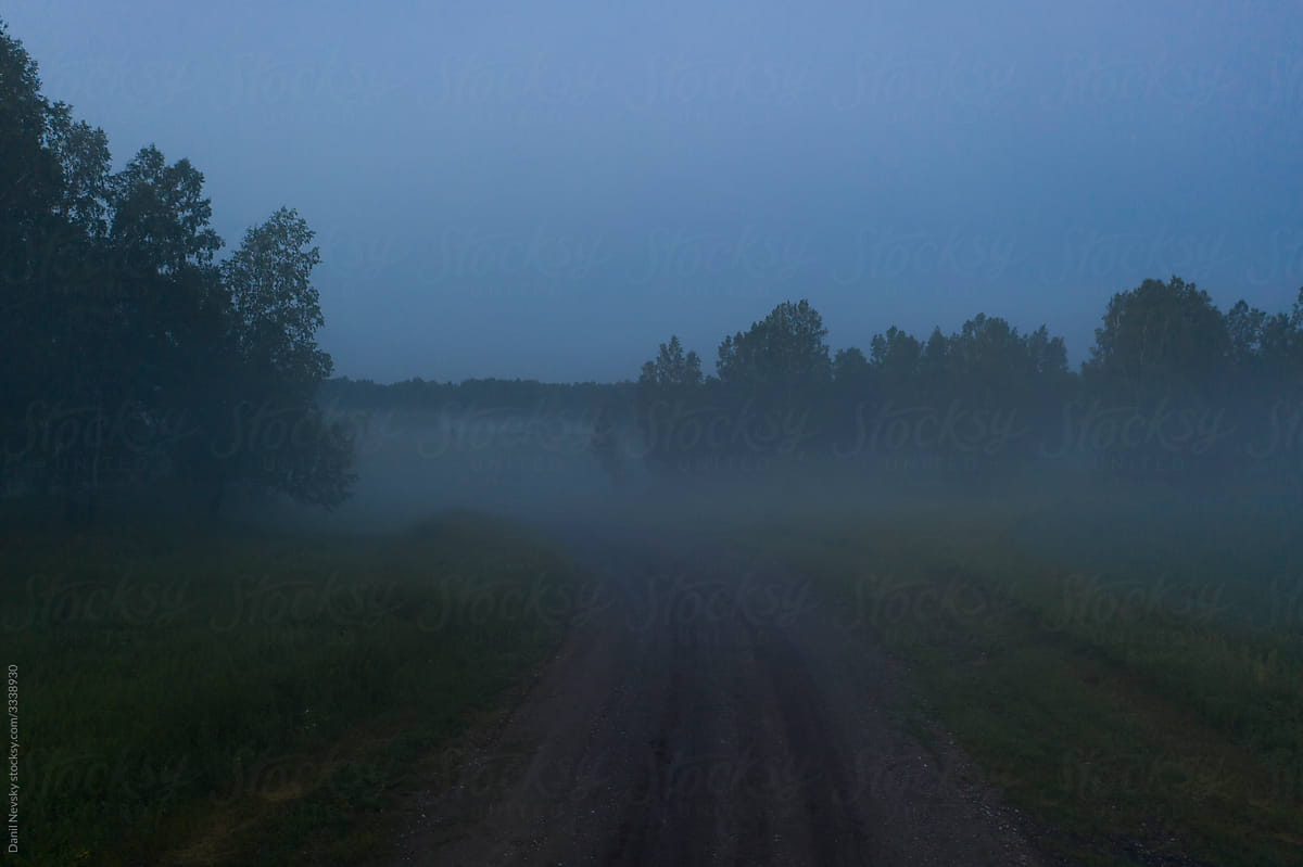Fog over countryside road in evening