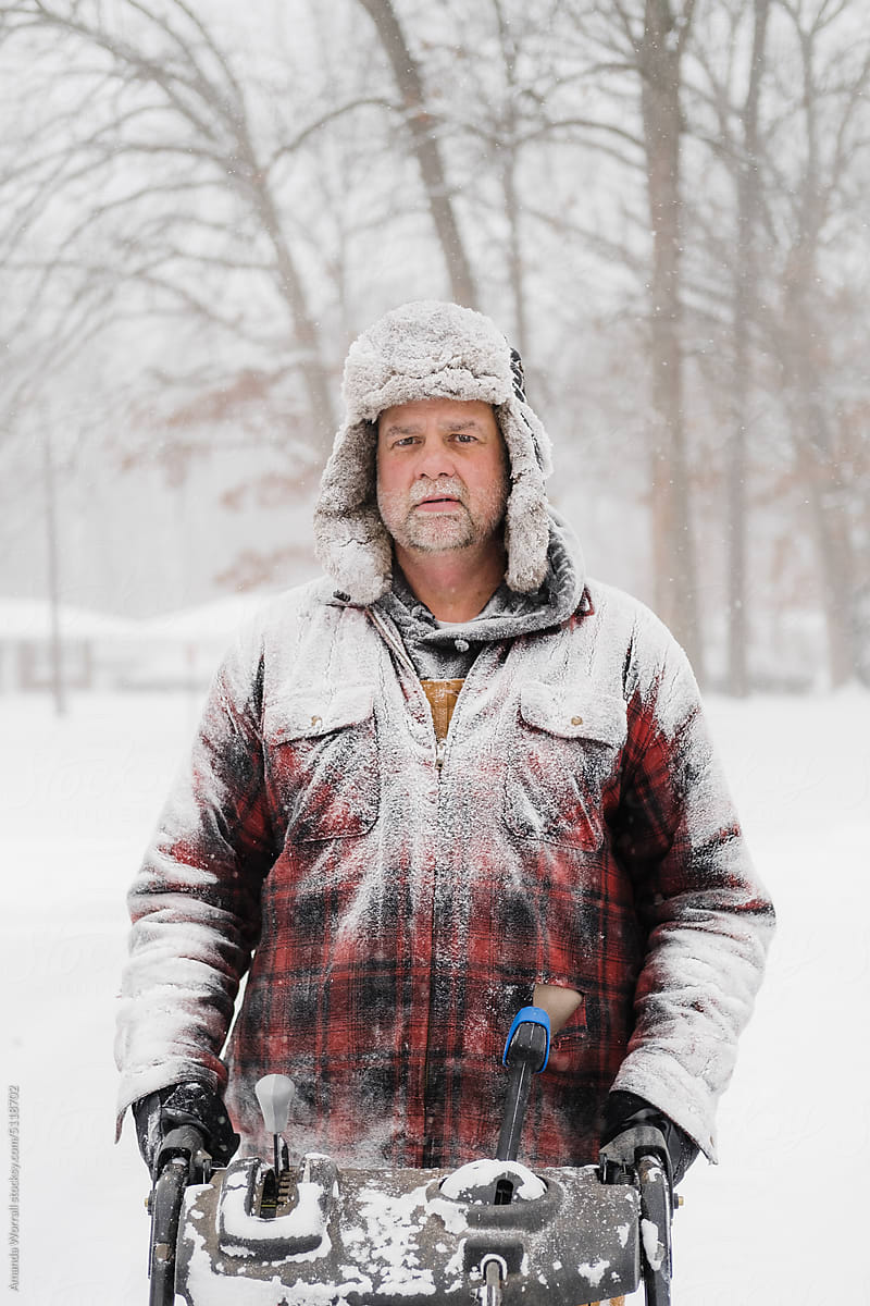 Portrait of man covered in snow wearing plaid coat during snow storm