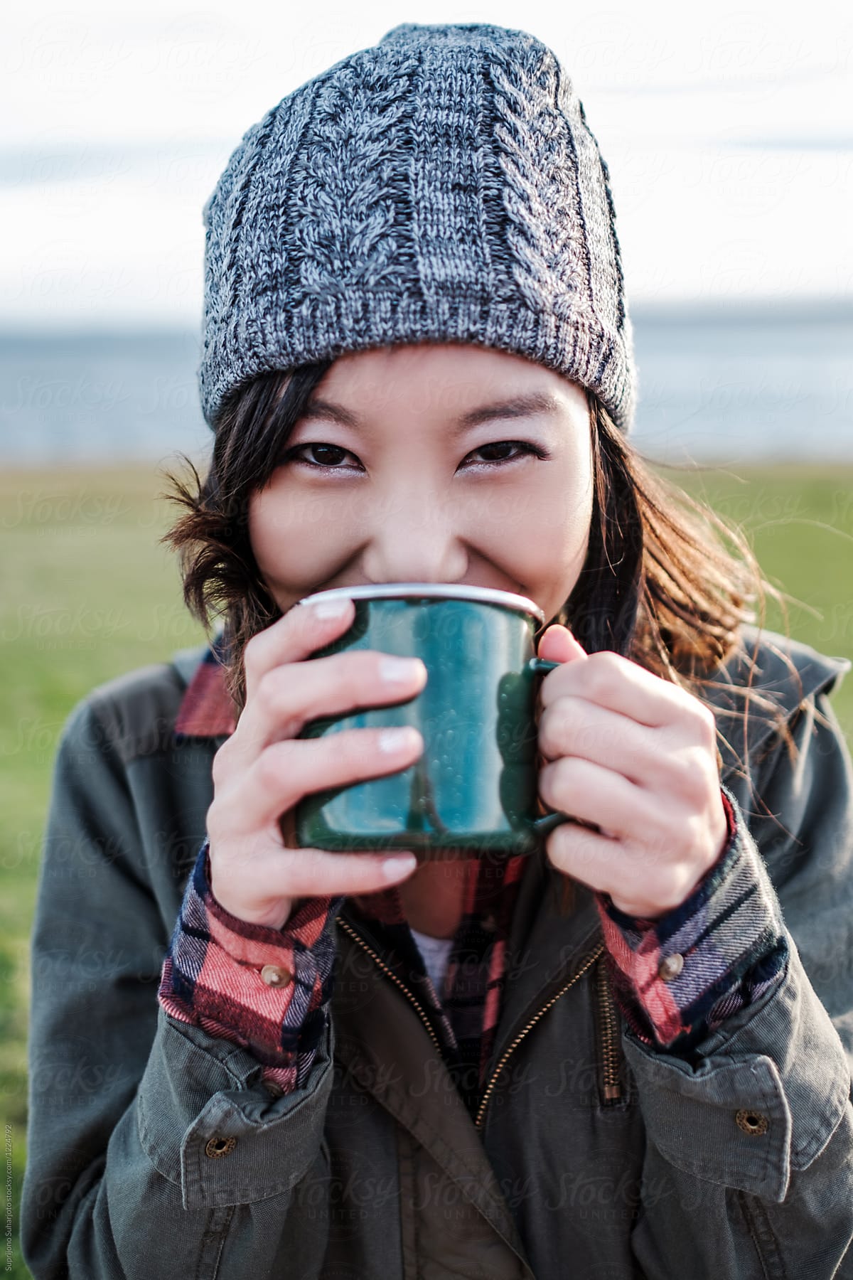 Beautiful Asian woman drinking hot tea in a mug