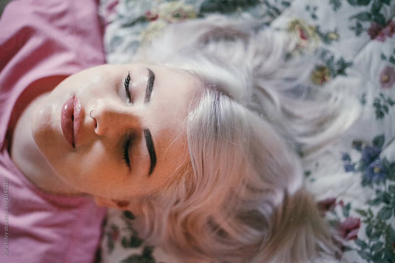 Blonde woman lying on floral bed