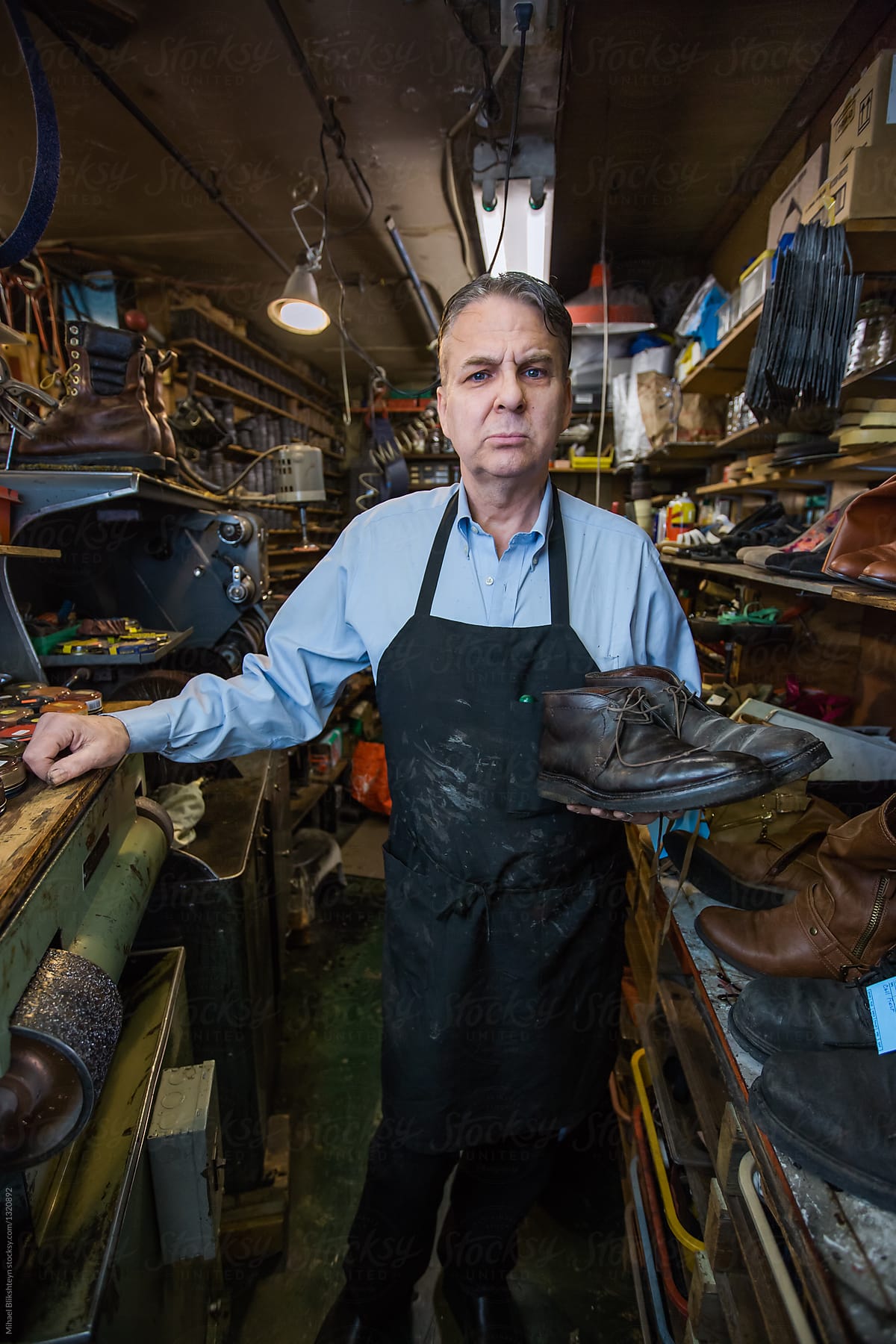 Stern-looking cobbler in his shoe repair shop
