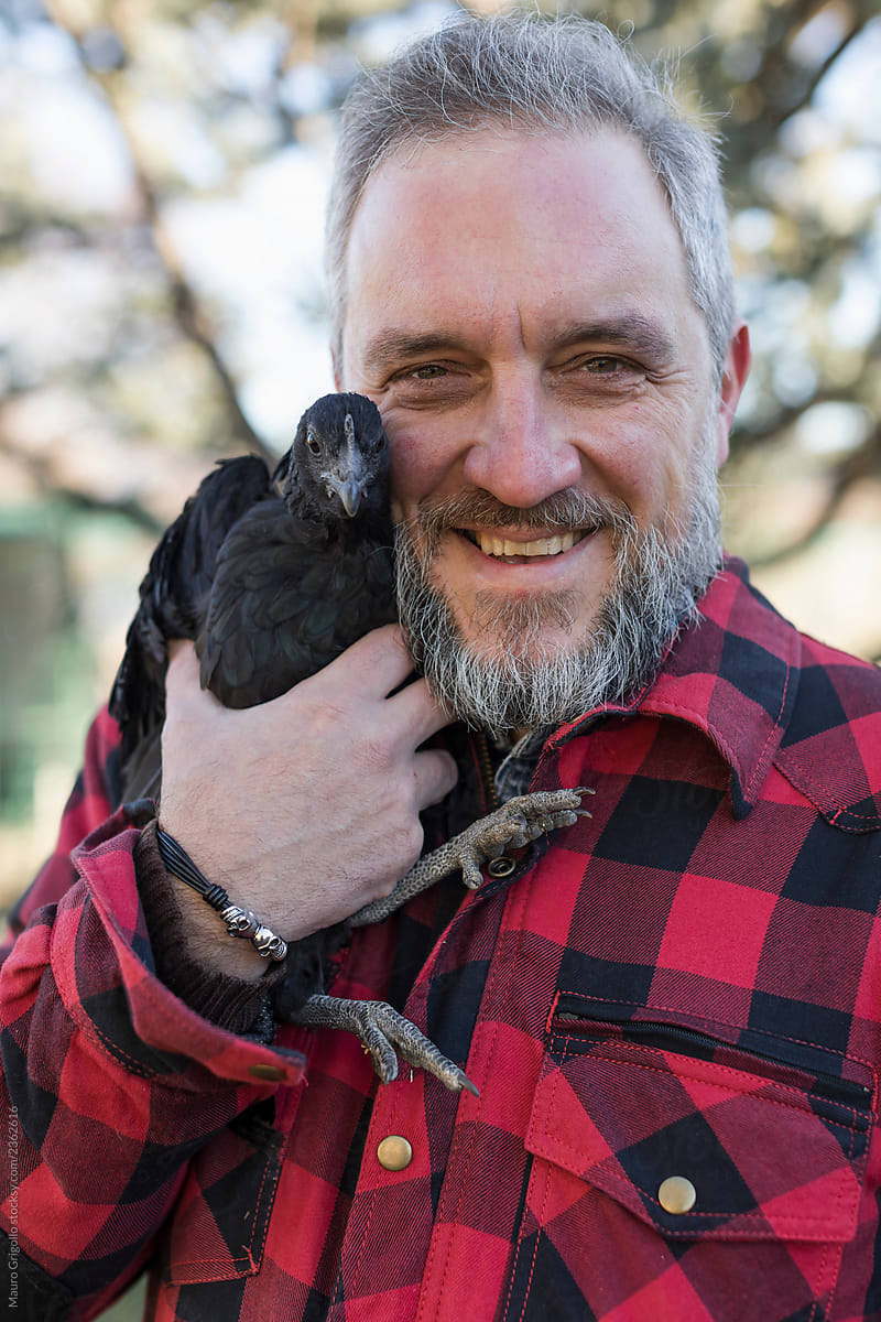 Smiling man holding a chicken