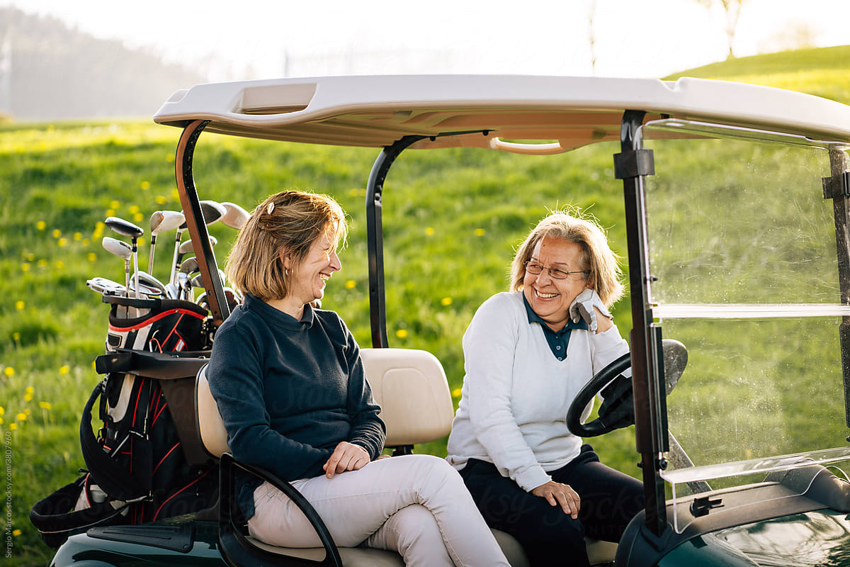 Women laughing at golf carts