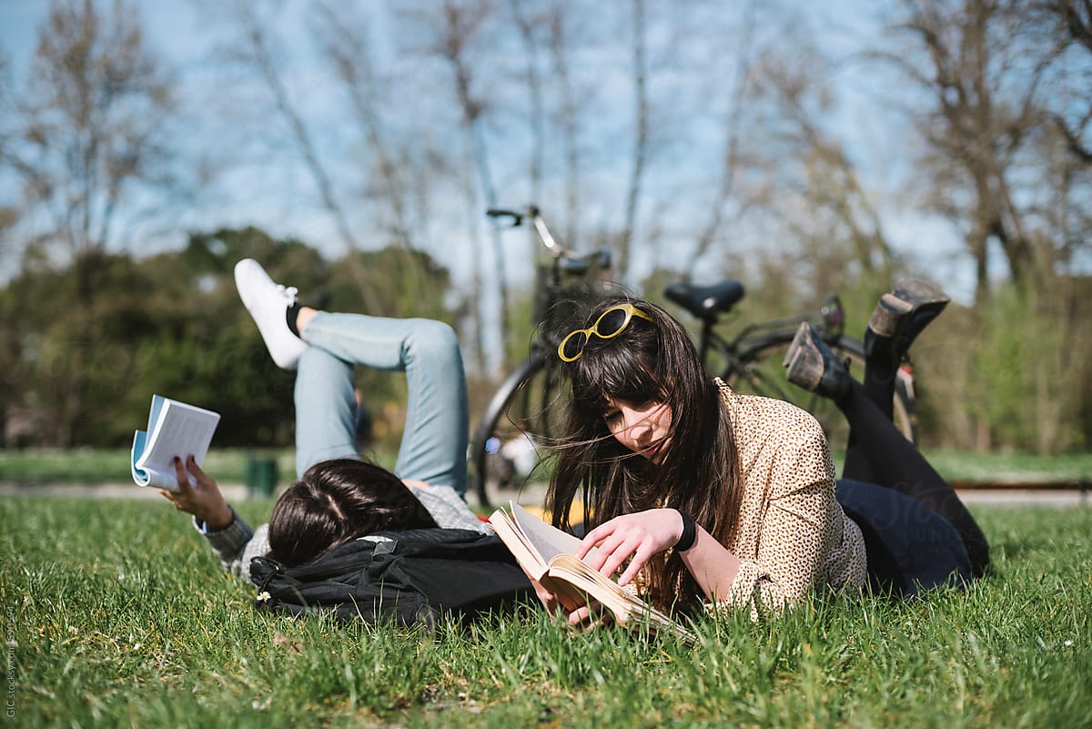 Young women studying lying in the park