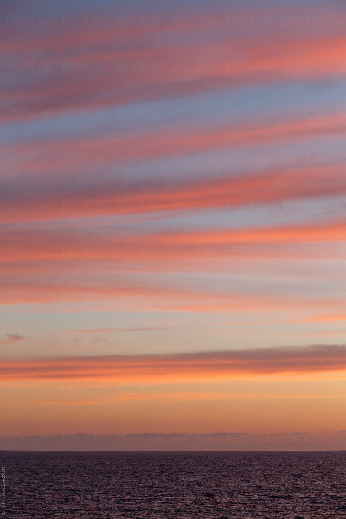 Seascape with stripes of clouds during sunset