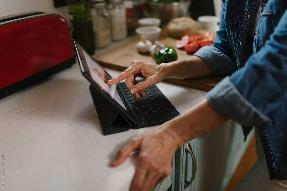 A person using a tablet in the kitchen