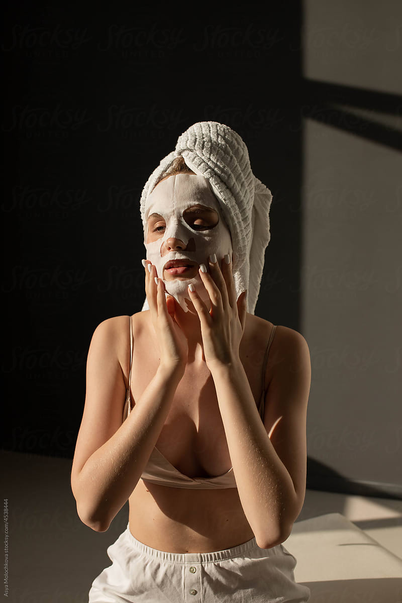 Young woman  applying cloth face mask after shower