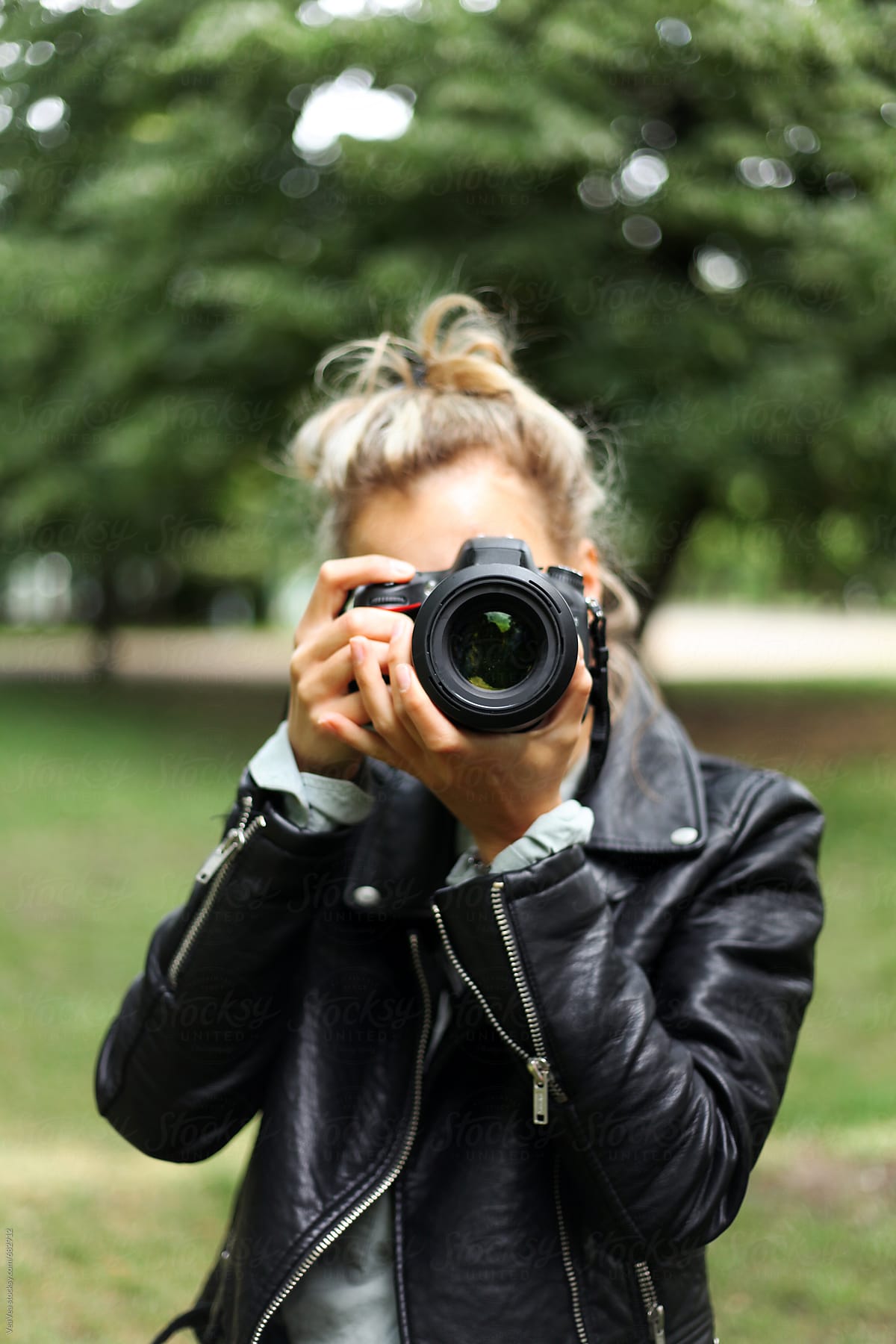 Young woman taking a photograph with photo camera