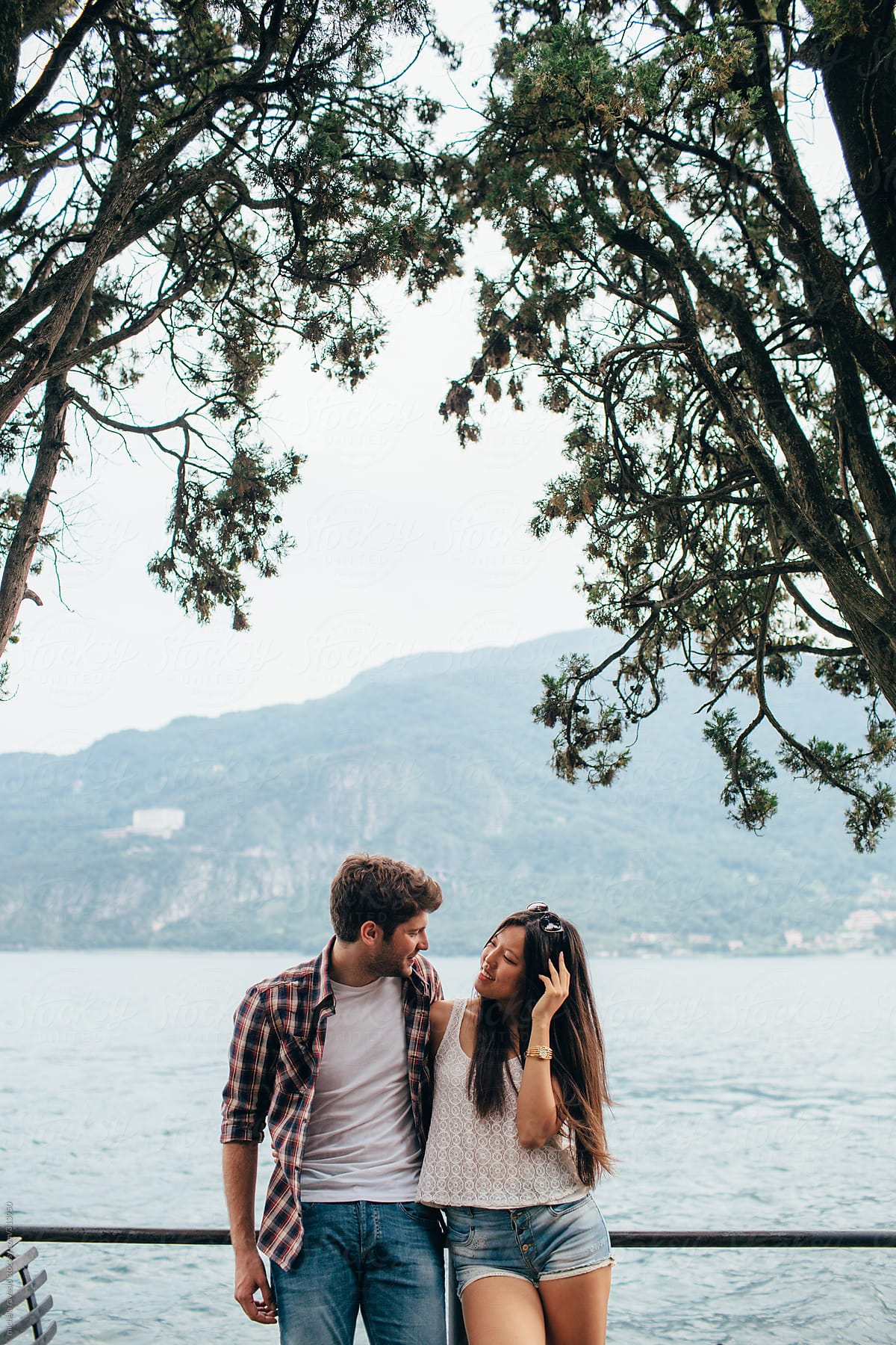 Young couple looking each other with  the lake on the background
