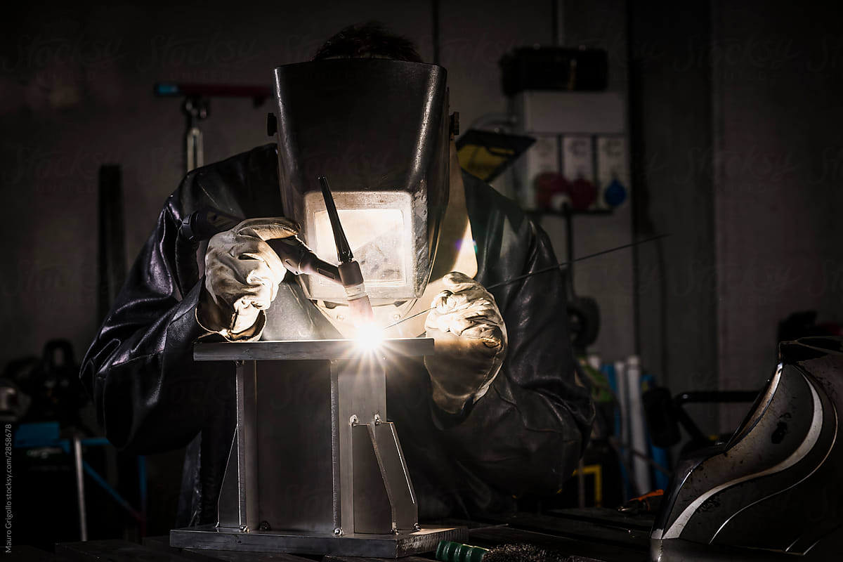 Welder welds aluminum in his workshop
