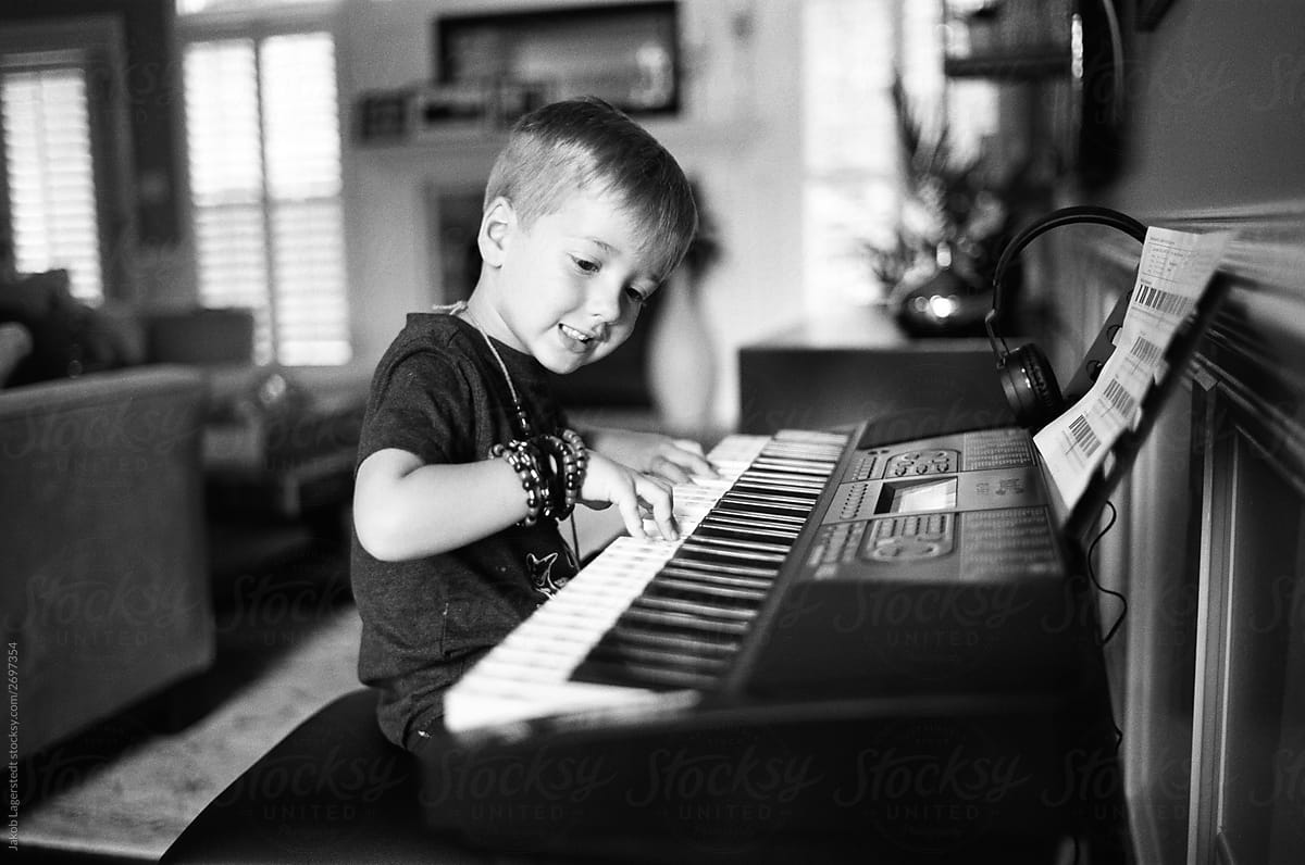 Cute young boy playing a keyboard piano