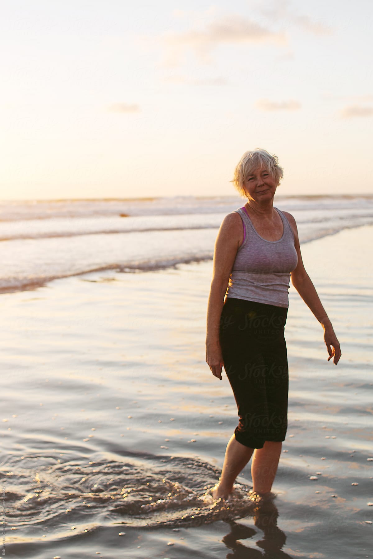 Mature woman enjoying herself on the beach Stock Photo - Alamy