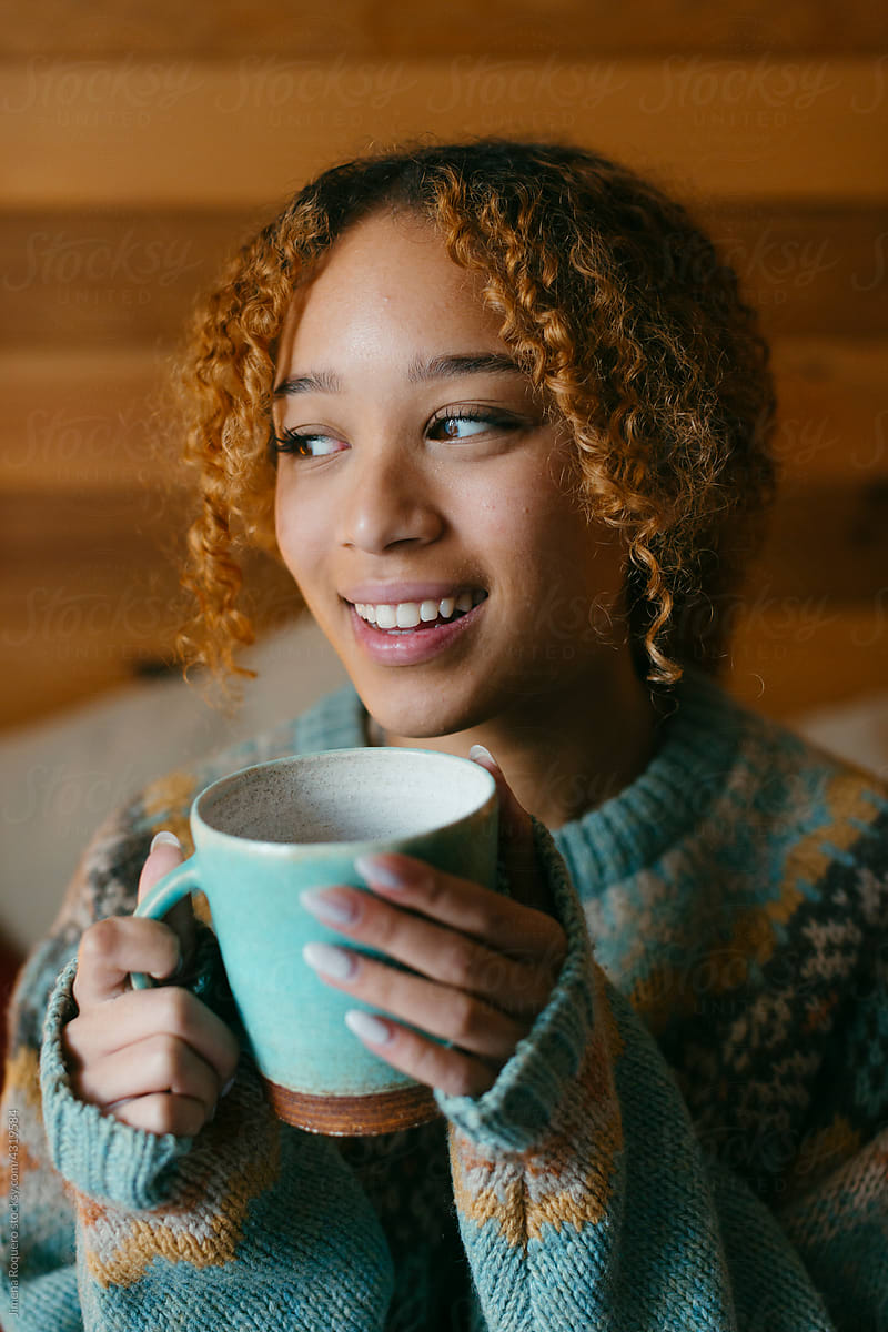 Young woman drinking tea in the bedroom