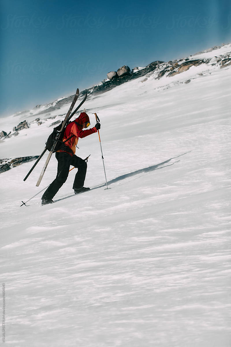 Skier Climbing Mountain in Very Windy Conditions