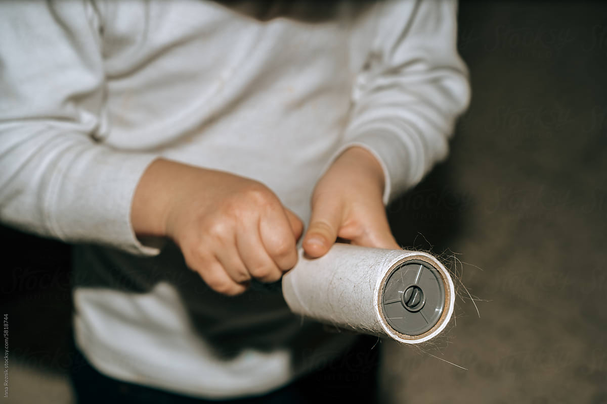 Boy Removes Hair-Covered Sheet from Roller After Clothes Cleaning.