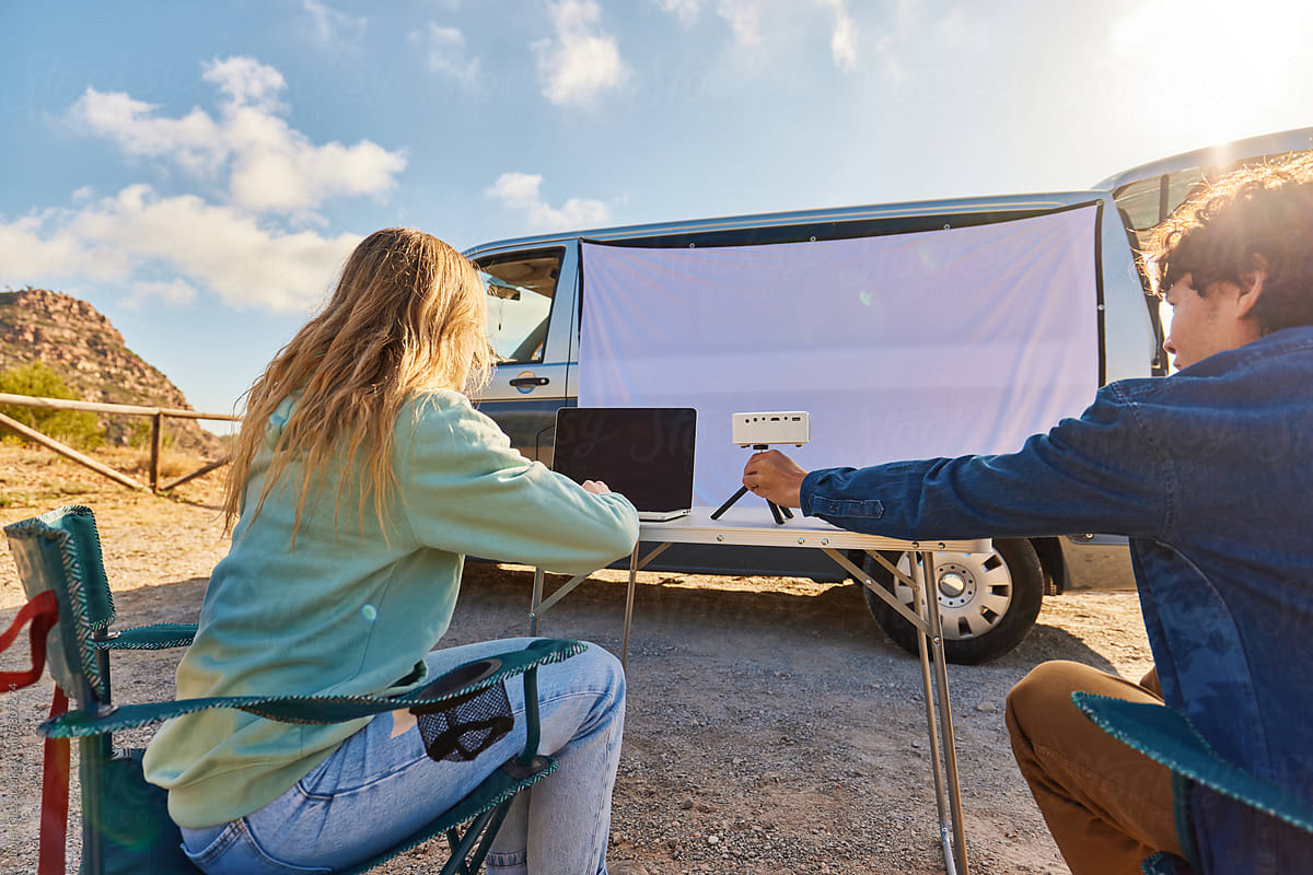 Young couple watching film in camper