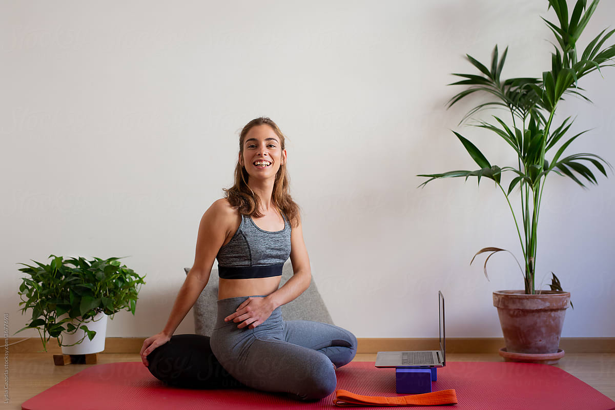 Young woman yoga online is her apartment